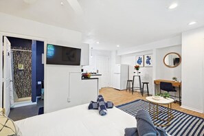 This stylish main living area features a smart TV, cozy seating, a breakfast bar, and a workspace, making it perfect for both relaxation and productivity