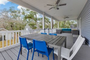 Additional seating and a table on the back balcony, perfect for enjoying the serene views of the surrounding trees and natural environment.