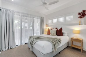 Relax in the first bedroom, featuring a comfortable queen bed, stylish décor and direct access to a private balcony for quiet mornings.
