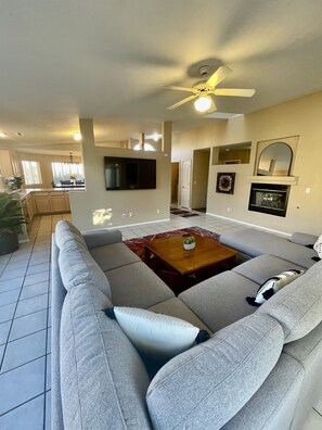This expansive living room offers plenty of space for everyone to spread out and relax. Whether you're curling up by the fire with a good book, watching a movie on the  60-inch Smart TV, or enjoying game night with friends, this space has it all