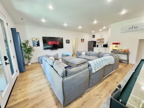 Movie room with 85” TV, modular couch, popcorn machine , and kitchenette
