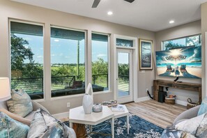Living room leads to covered waterside patio