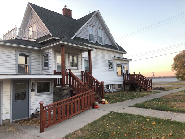 Exterior view showing main home entry with the lake in background.
