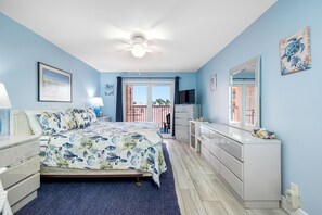 Spacious master bedroom with dresser and smart TV