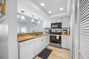 Fully equipped kitchen with granite countertops, stainless steel appliances, and plenty of counterspace for cooking and preparing meals