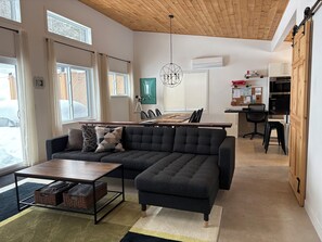 Spacious living area with knotty pine high sloped ceiling and great forest views