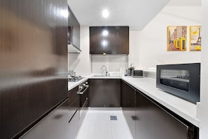 Kitchen: Sleek black cabinetry and modern appliances inspire your culinary adventures!