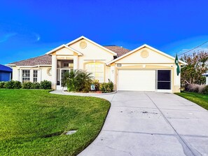 Lush landscaping, palm trees, and a welcoming entrance await you.