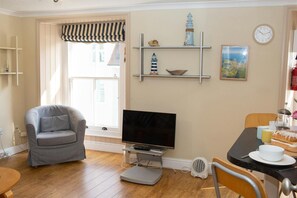 TV, armchair and large window with blinds