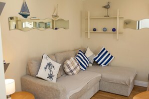 Corner sofa with wall mounted mirror and shelving above