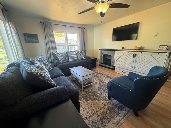 Living room with Queen Murphy bed, and fireplace.