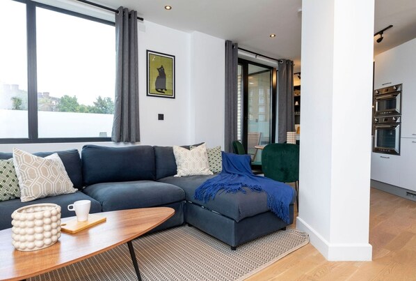Spacious open living area with a connected kitchen, a stylish dining table, a comfortable sofa bed and Smart TV