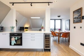Open-plan living and kitchen area with access to three balconies
