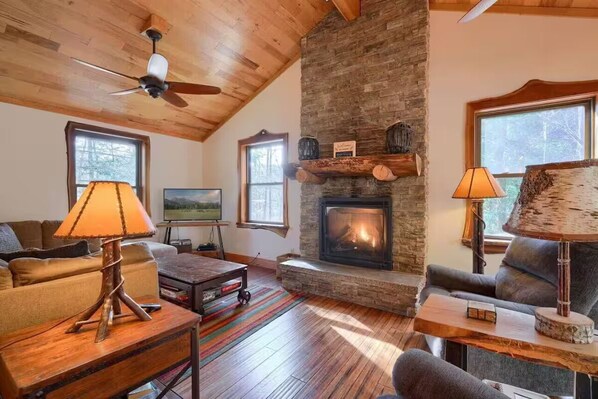 Main floor living room with cozy seating, gas fireplace, games, and books
