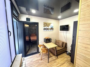 Kitchenette, dining table, fridge, TV, wardrobe – all in one cozy studio.