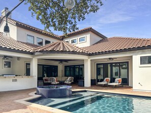 "Step into paradise with our stunning pool and expansive patio! Enjoy multiple seating areas for lounging, dining, and soaking up the sun, all complemented by a fully-equipped outdoor kitchen