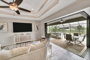 Large living room with pool &amp; canal view and 85-inch Smart TV
