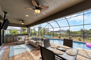 Perfect outdoor space overlooking the pool and canal. Lanai features outdoor kitchen, dining &amp; seating areas, sun loungers &amp; 54-inch Smart TV