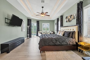 Large primary bedroom with king bed, en suite, lanai access, and 55-inch Roku TV