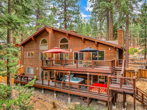 Exterior: View of the back of the home, upper and lower deck, hot tub, outdoor dining, access to backyard