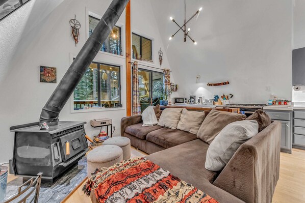 Living Room: Large sectional, wood-burning fireplace, 65” Smart TV
