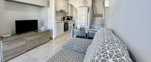 Modern and comfortable living-dining room, open to the kitchen, which creates a spacious and bright space perfect for sharing moments in a cosy and functional atmosphere.