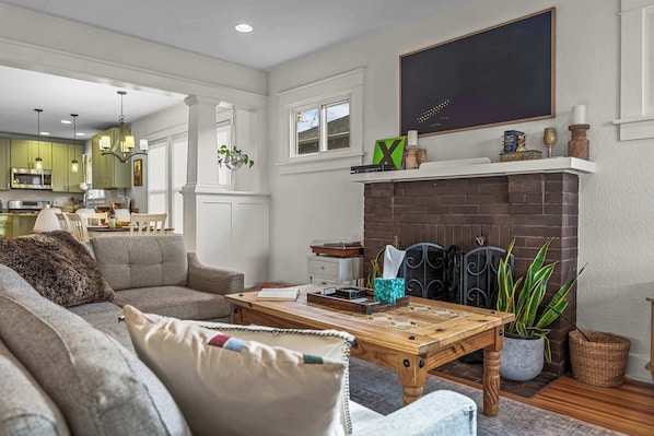The upstairs living room opens to the spacious kitchen and has a unique framed TV