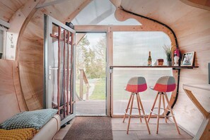Bright Living Area Light-filled interior with colorful bar stools and cozy seating, opening to a view of the outdoors. (2)