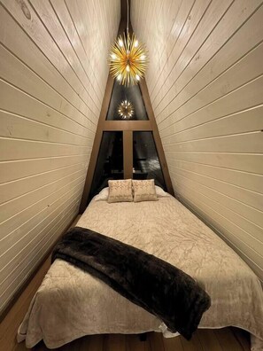 Loft queen bed at night. The starburst light is on a dimmer to ensure the perfect lighting when relaxing to sleep.
