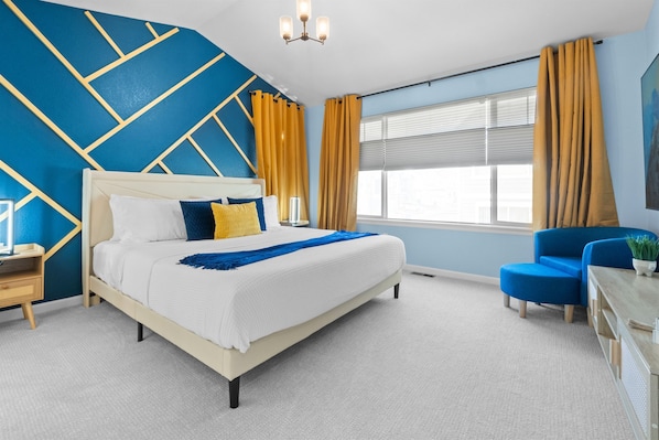 Spacious primary bedroom featuring a luxurious 75-inch smart TV for ultimate relaxation and entertainment