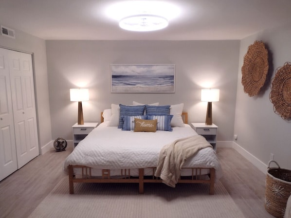 Spacious master bedroom featuring a king-size bed with plush bedding, coastal-inspired decor, natural light, and a serene, relaxing atmosphere at Hilton Head Hideaway.