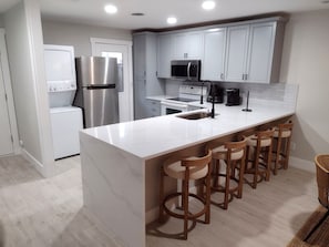 Fully equipped kitchen with modern appliances and a spacious breakfast bar with seating—perfect for cooking, dining, and gathering at Hilton Head Hideaway.