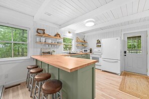 The kitchen invites you to prepare a meal while staying connected to nature through the large windows, letting in the calm of the outdoors.