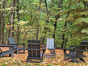 Enjoy the beauty of nature from the cozy outdoor seating area, where you can gather around the fire pit and make memories under the trees.