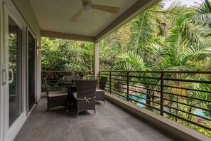 Relax on the private balcony with a peaceful pool view.
