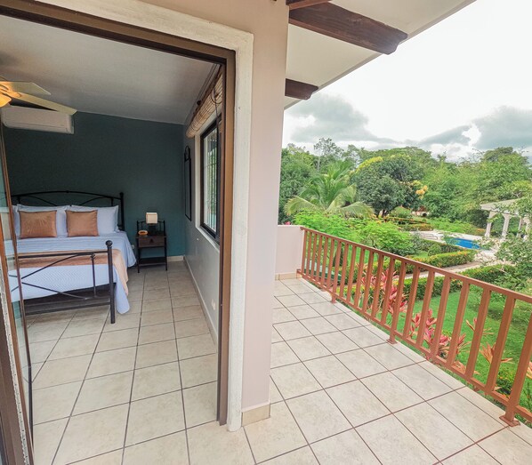 Spacious bedroom with terrace and poolside view.