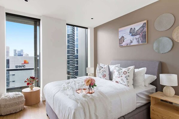 A bedroom with a queen sized bed & plush pillows.