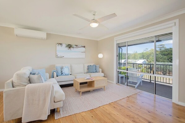 The living and dining area is open plan with the front porch on one side and the back deck on the other.
