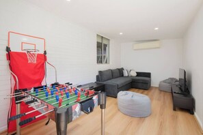 A dedicated games room includes a foosball table and TV area for movie nights at home.