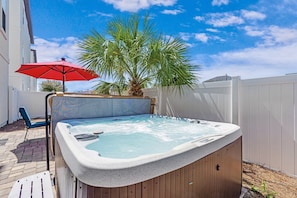 Private backyard with hot tub, grill, lounge seating, and outdoor dining table