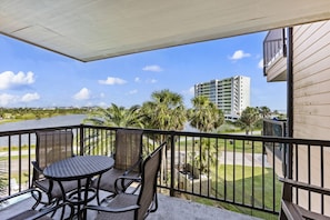 Relax on the balcony with stunning water views and lush palm trees