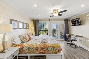 Bright master bedroom with ocean view, desk and cozy decor