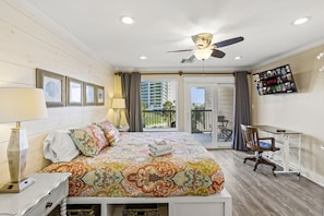 Bright master bedroom with ocean view, desk and cozy decor