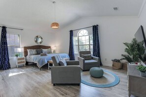 The primary bedroom is a relaxing retreat, complete with a luxurious king-sized bed, a smart TV for your entertainment, an ensuite bath for added privacy, and two cozy side chairs, perfect for unwinding after a day of exploring.