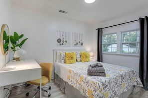 Unwind in the third bedroom, featuring a comfortable queen bed, a convenient desk for work or planning your day, and extra pillows for added comfort.