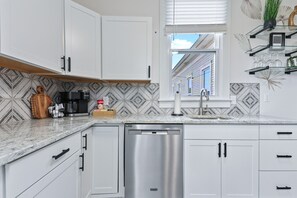 The fully equipped kitchen features a gas range and sleek stainless steel appliances, ready for creating delicious meals and memorable moments. 🍽️✨