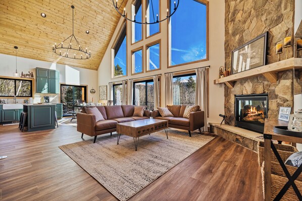 As you make your way into the great room, you are greeted by floor to ceiling windows