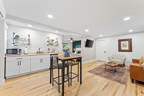- Modern studio space with a full kitchenette, open lounge, & cozy seating
- Industrial touches meet farmhouse charm with butcher block counters & pipe shelving
- Perfect all in one retreat for small groups or couples, complete with TV & dining nook