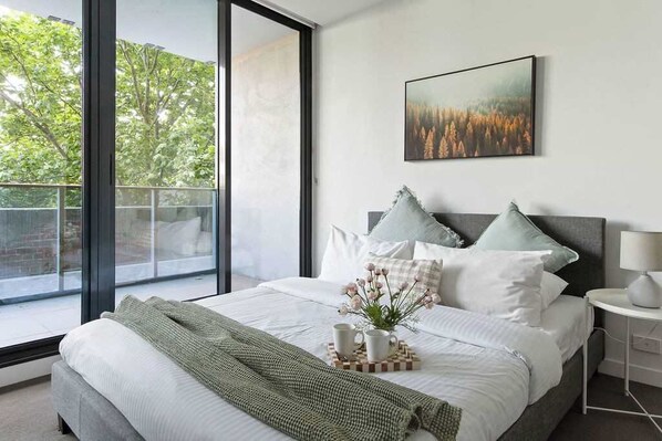A bedroom with a queen sized bed & plush pillows.