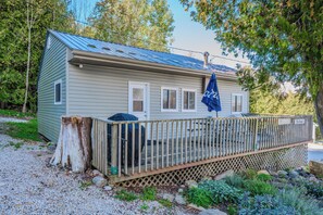 A spacious side deck with additional seating and a grill, offering a peaceful outdoor dining space.